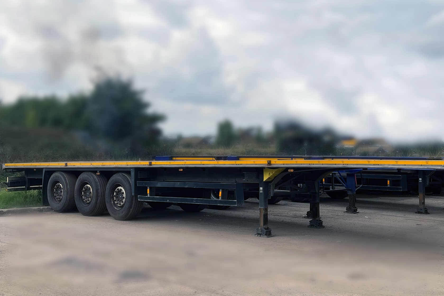 Parked JBS-Flatbed-Trailer angled with the front & side view visible